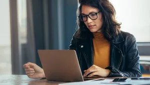 Woman with glasses on laptop