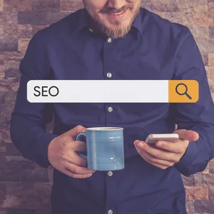 Man holding phone and coffee with SEO search bar