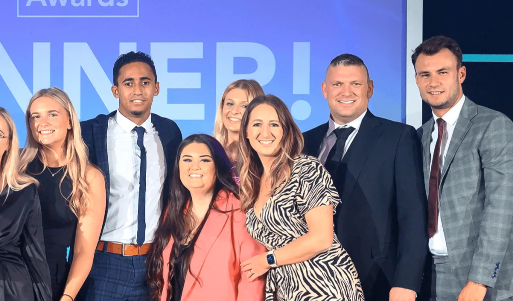 The Absolute Digital Media team on stage in front of an awards winner screen