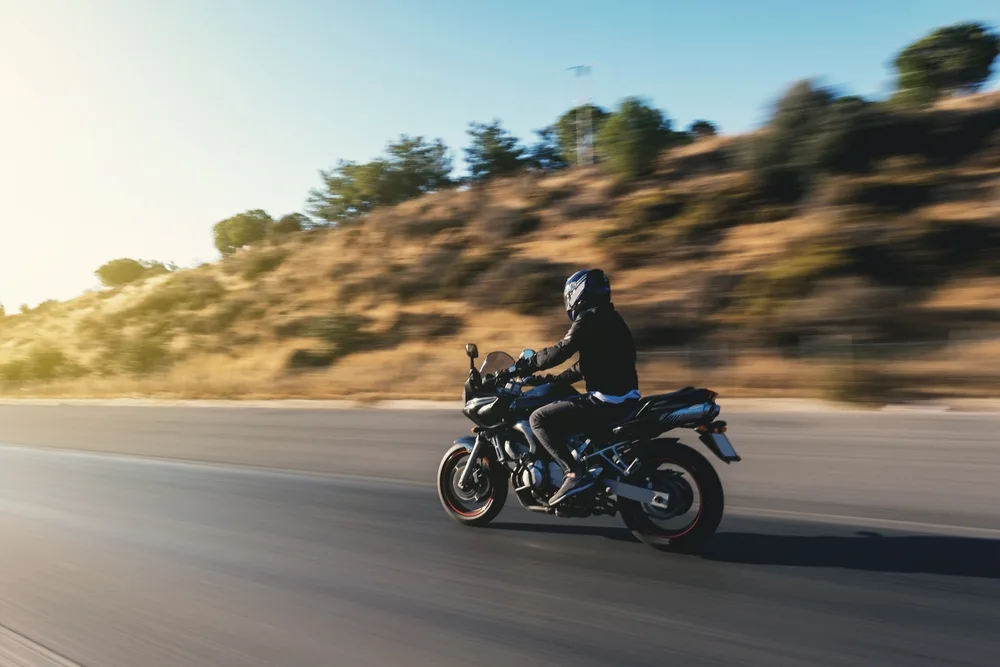 Side View Of A Motorcycle Rider Riding On The Highway