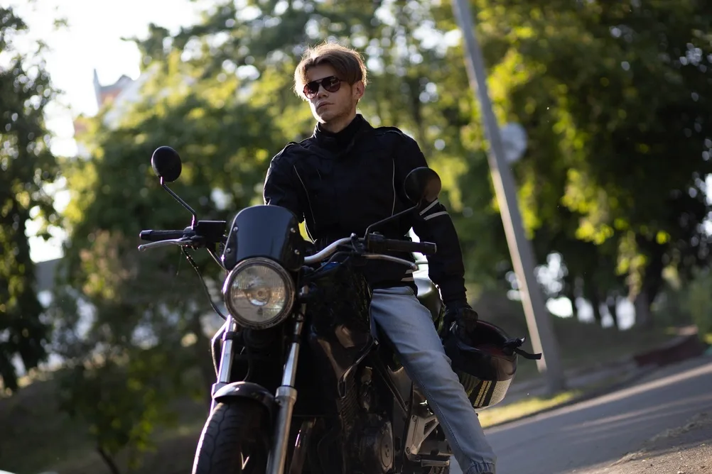 A Man Motorcyclist Riding A Motorcycle In The Greenery In