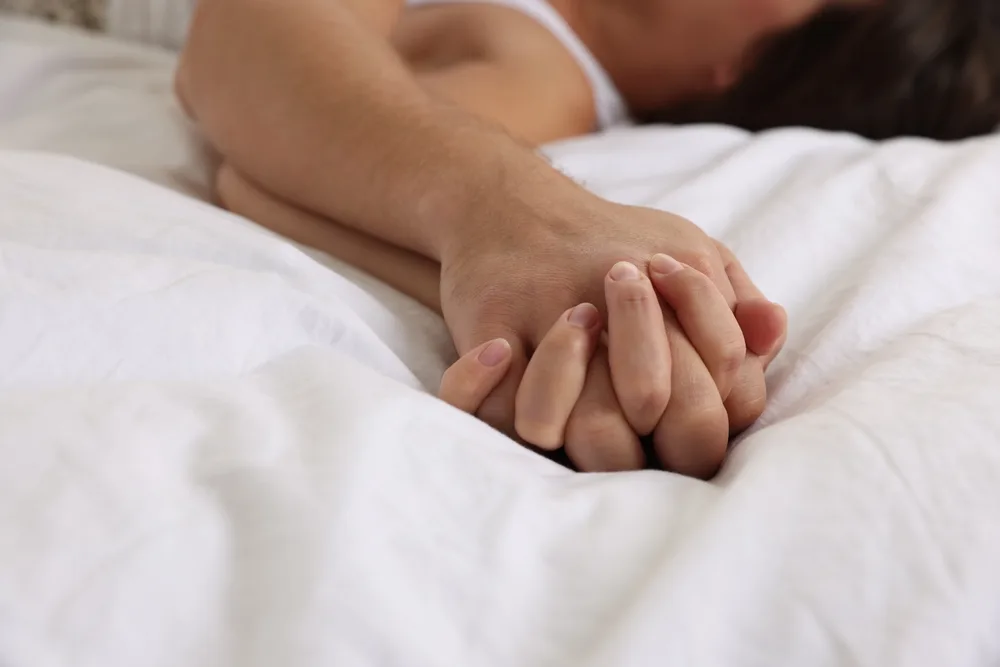 Lovely Couple Holding Hands In Bed Closeup