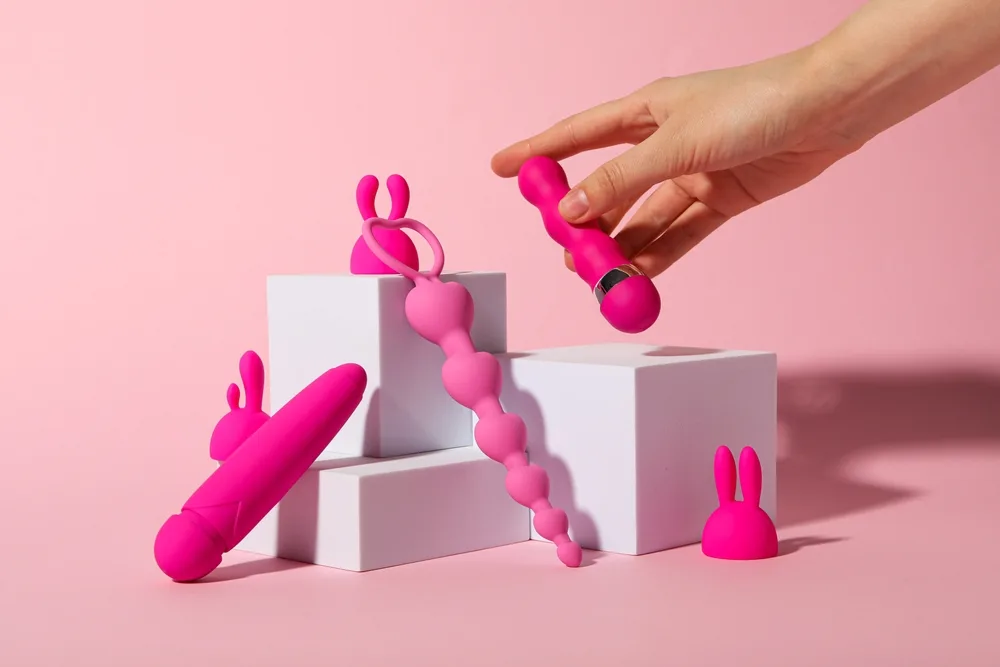 Pink adult wellness products displayed on white studio plinths