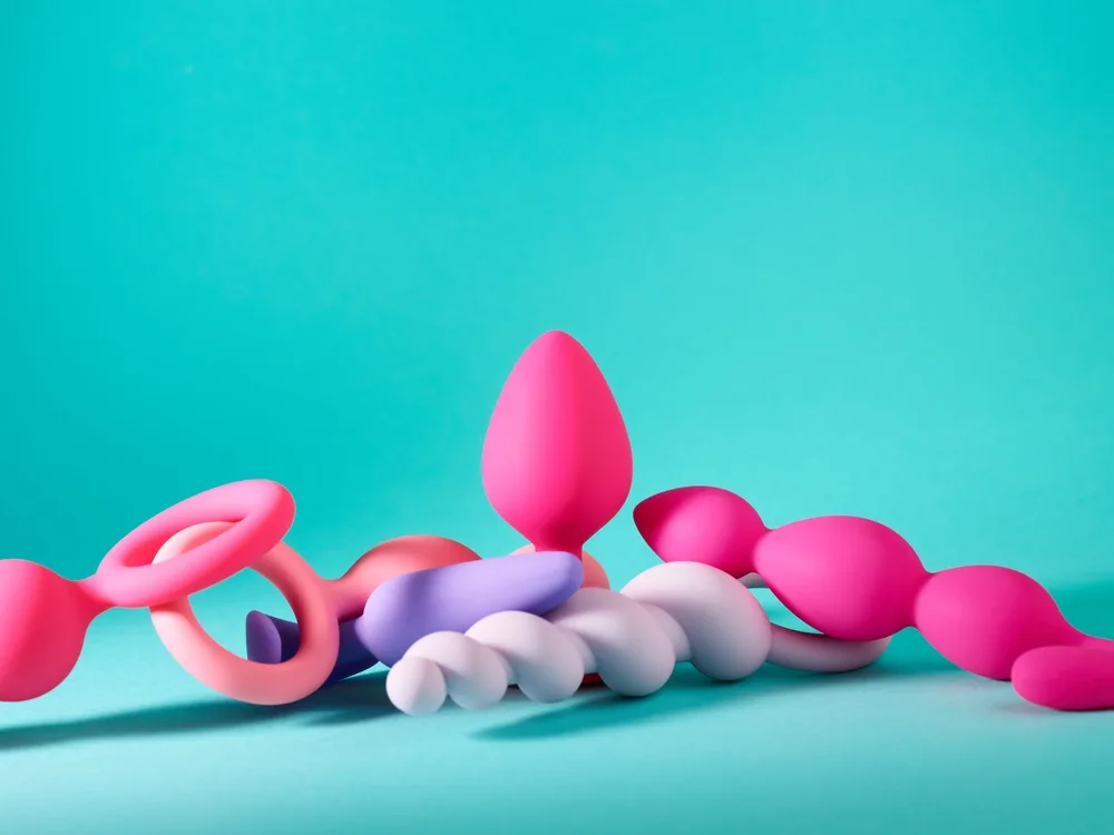 A group of adult wellness products on a bright teal background
