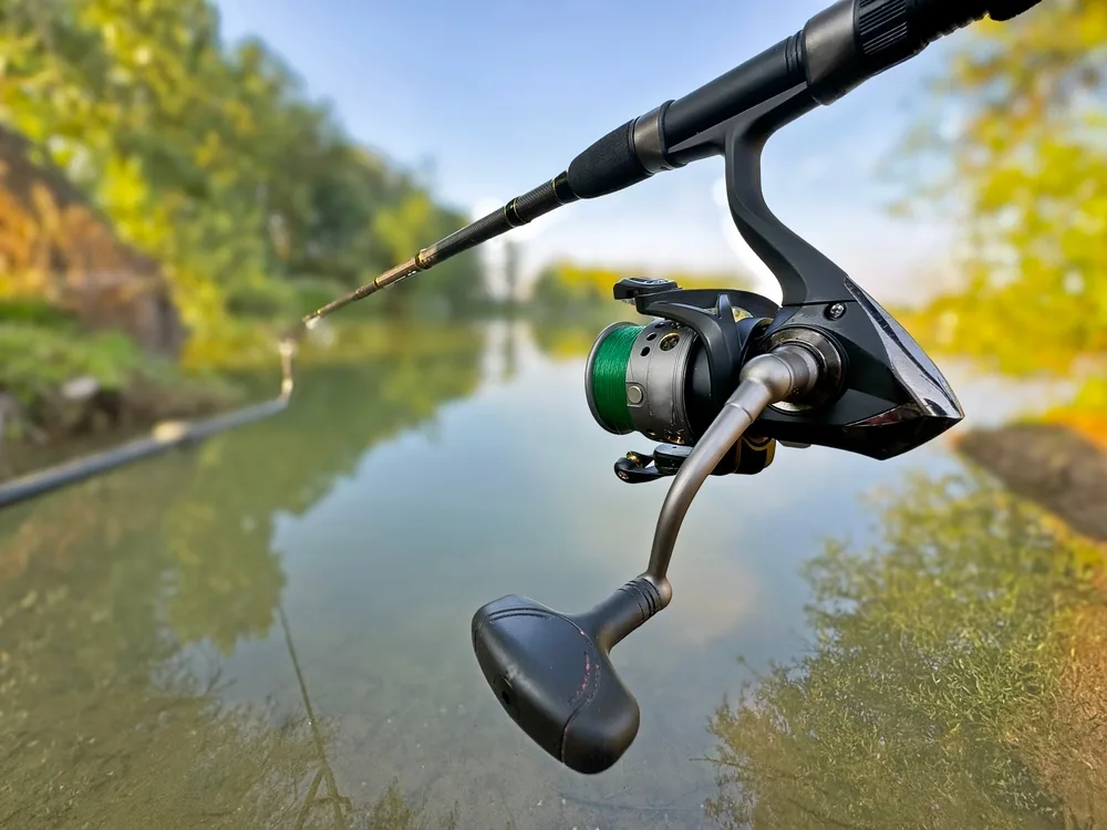 Close view of a spinning reel and rod above open water